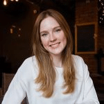 Smiling woman in a cozy cafe setting.