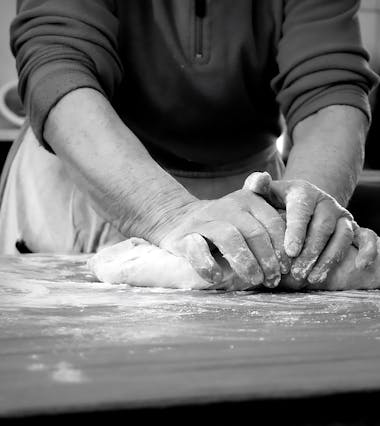 Person kneading dough on floured surface